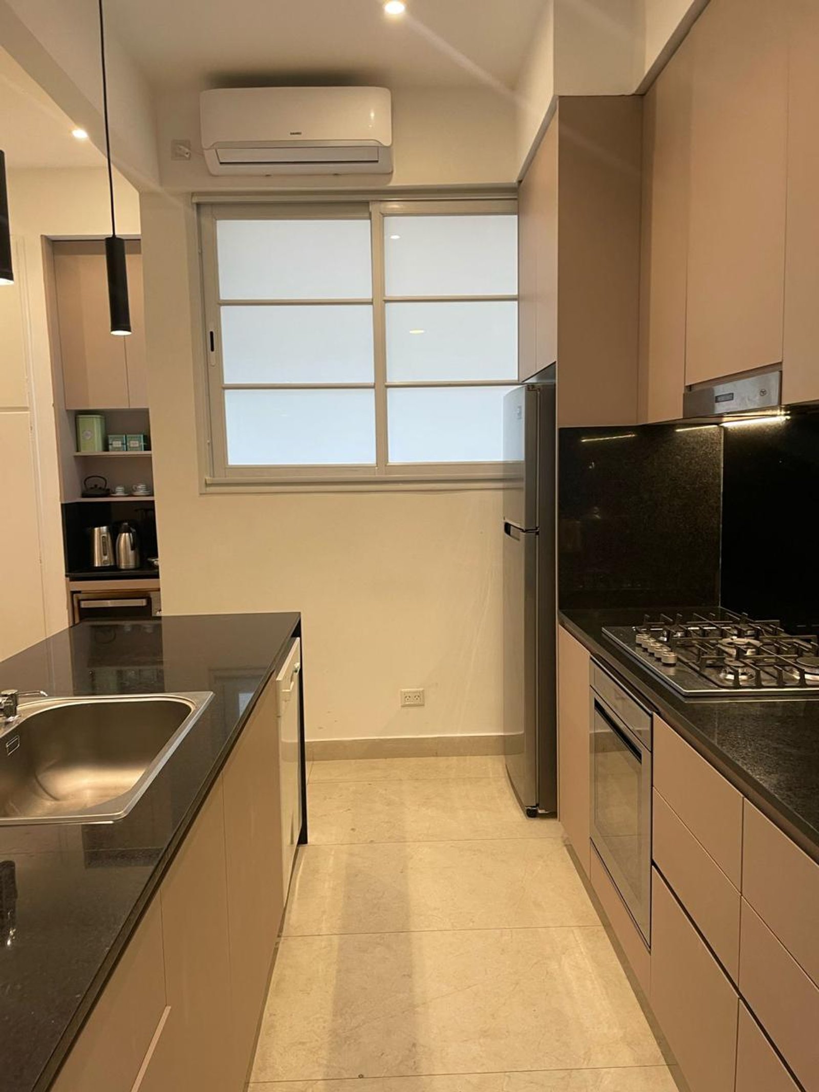 Cocina moderna con isla, muebles beige y mesada de piedra negra — proyecto Paraguay , por Estudio NET Arquitectura , en Paraguay 1546